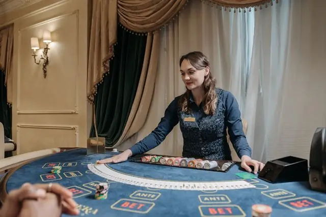 Roda roulette dan kartu remi di meja kasino dengan dealer — ilustrasi artikel live casino Ahha4d