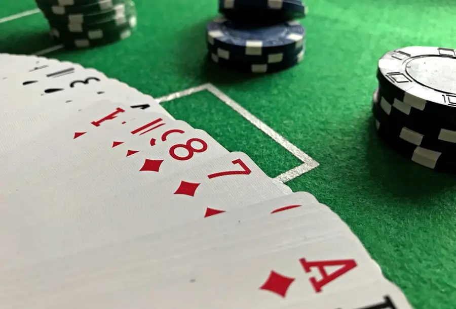 Pemain poker memegang kartu dan keping di meja — ilustrasi artikel poker online Ahha4d